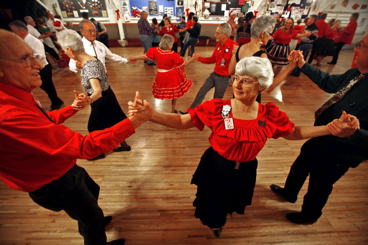Bob Soman, left, 81, of Hemet; Cathy Emery,69, of Riverside; and Bruce Turner, 61, of Grand Terrace; dance together during the last dance of the night at Cowtown Square Dance Center in Riverside in December. The three are members of a dancing club that regularly meets at the hall.