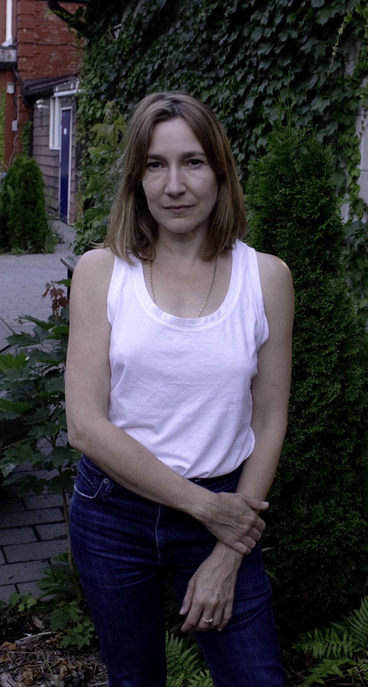 A woman in jeans and a white tanktop