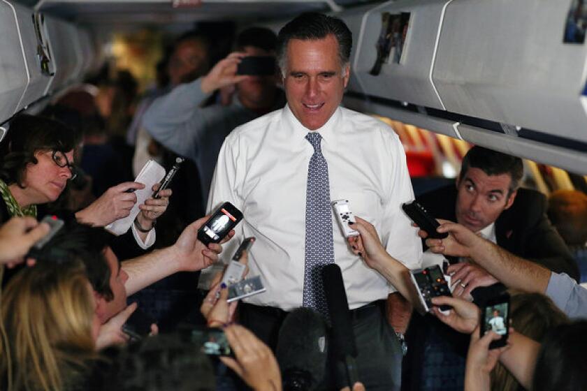 Republican presidential nominee Mitt Romney talks with members of the traveling media aboard his campaign plane en route to Boston.
