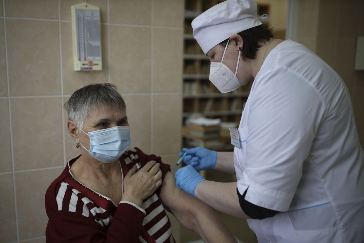 A medical worker administers a shot of Russia's coronavirus vaccine to an elderly woman in Korenovsk, Krasnodar region, 1151 km south of Moscow, Russia, Saturday, Nov. 13, 2021. The chief sanitary doctor of the Krasnodar region introduced compulsory vaccination against coronavirus for residents of 60 years and older. Russia is reporting a new daily high number of COVID-19 deaths, while the the total number of coronavirus infections during the pandemic in the country has topped 9 million. (AP Photo/Vitali Timkiv)