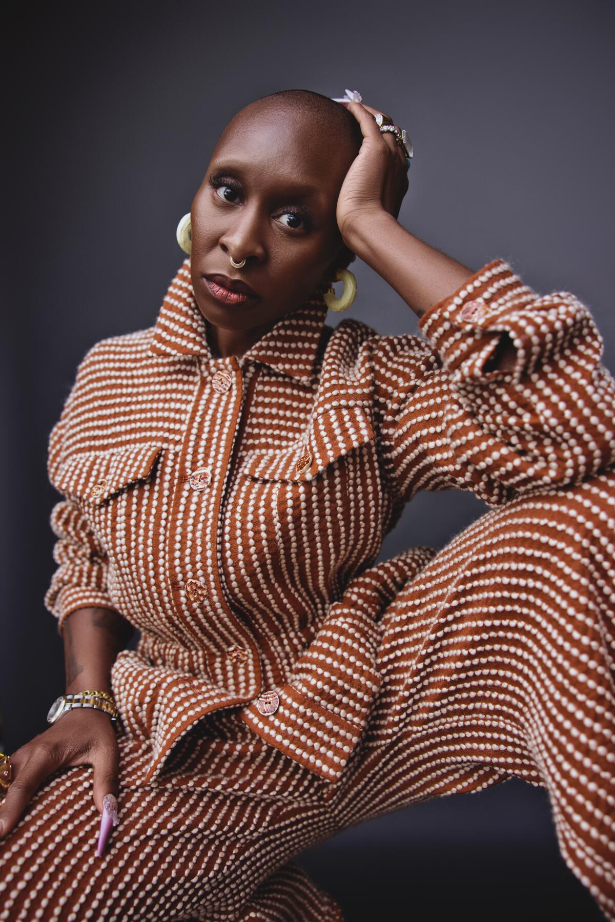 Cynthia Erivo poses for a portrait, leaning her head on her hand.