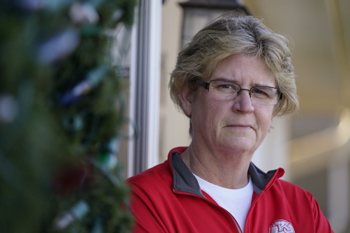 Keli Paaske stands outside her home in Olathe, Kan. Friday, Dec. 4, 2020. Paaske was laid off in August from a company supplying fire doors to hospitals after being furloughed for five months and has struggled to find a new job. (AP Photo/Charlie Riedel)