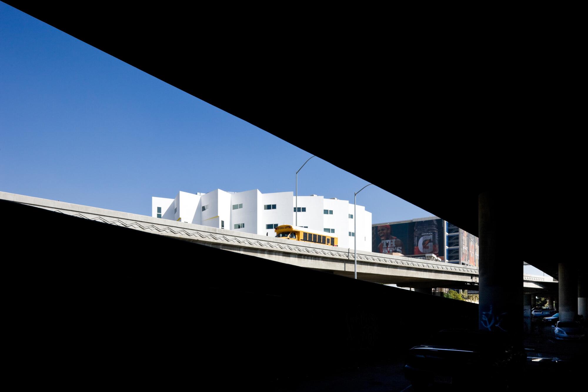 The top of the New Carver Apartments pleated white facade can be seen through two elevate freeway ramps.