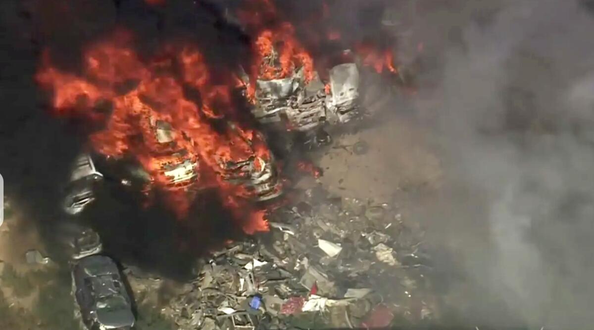 Flames engulf objects in a junk yard.