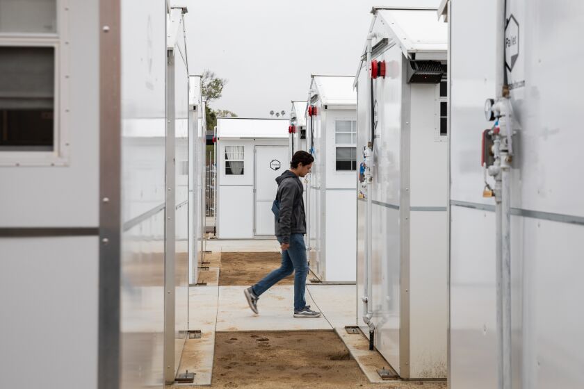 Chula Vista, CA - May 17: A CityNet employee walks through shelter units at the new Chula Vista bridge shelter in Chula Vista, CA on Wednesday, May 17, 2023. (Adriana Heldiz / The San Diego Union-Tribune)