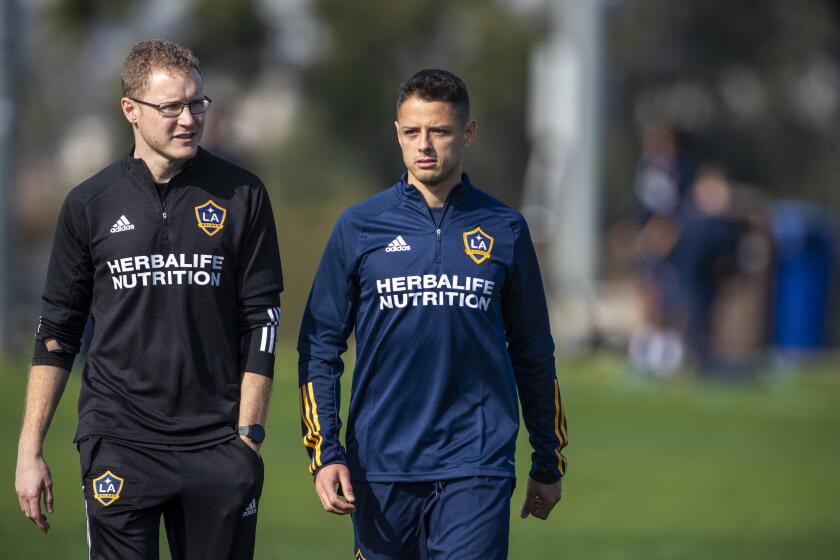 CARSON, CALIF. -- THURSDAY, JANUARY 23, 2020: LA Phil Hayward, left, LA Galaxy head of sports science, walks and talks with Galaxy’s new player Javier 'Chicharito' Hernandez on to the practice field to greet coaches and teammates before being formally introduced at a news conference at Dignity Health Sports Park in Carson, Calif., on Jan. 23, 2020. (Allen J. Schaben / Los Angeles Times)