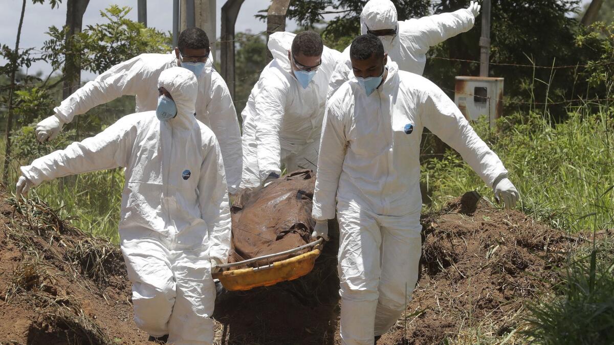 Rescue workers carry a body they pulled from the mud after a dam collapsed and flooded Brumadinho, Brazil.