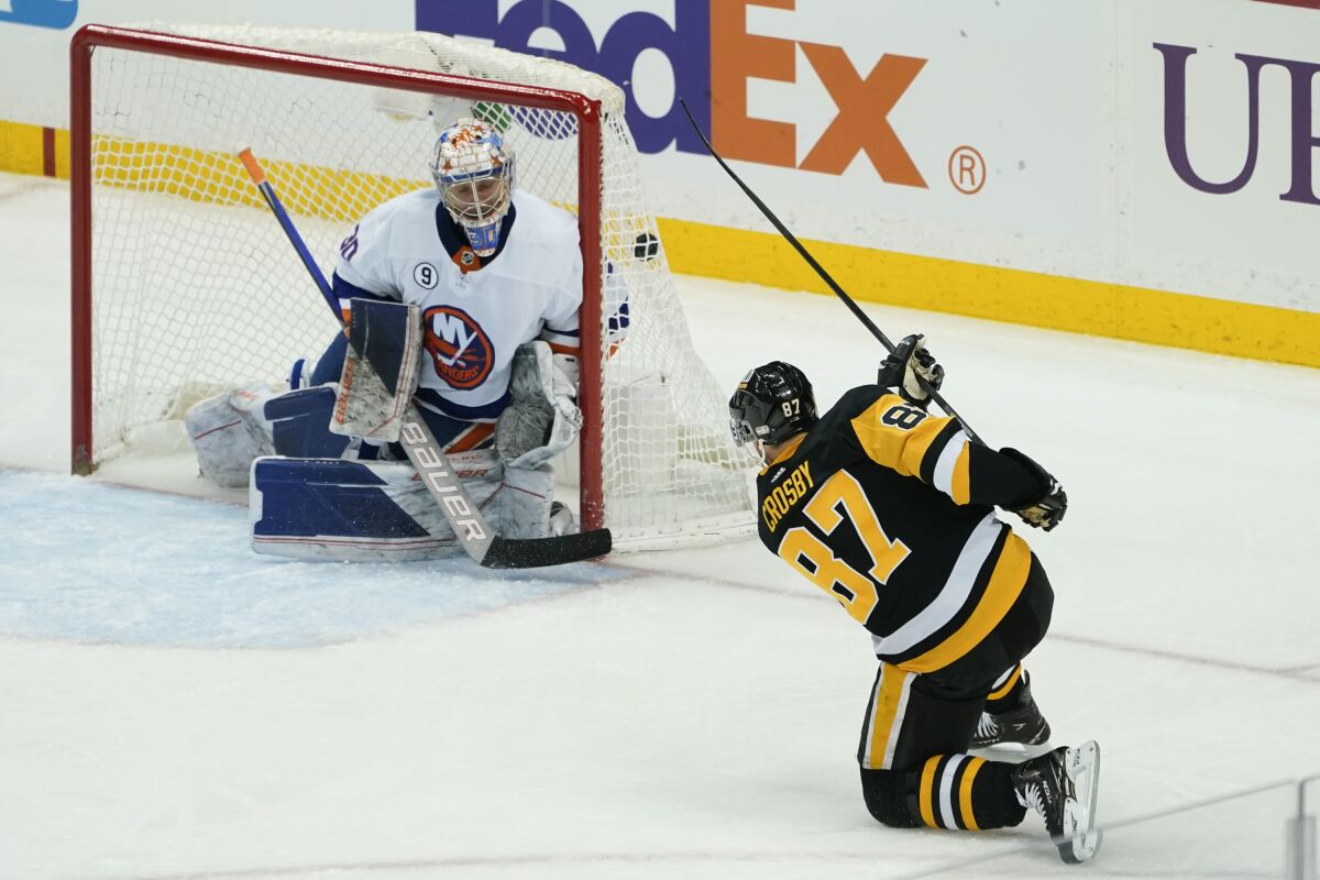 Pittsburgh Penguins' Sidney Crosby (87) scores against New York Islanders goaltender Ilya Sorokin (30) during the third period of an NHL hockey game, Thursday, April 14, 2022, in Pittsburgh. (AP Photo/Keith Srakocic)