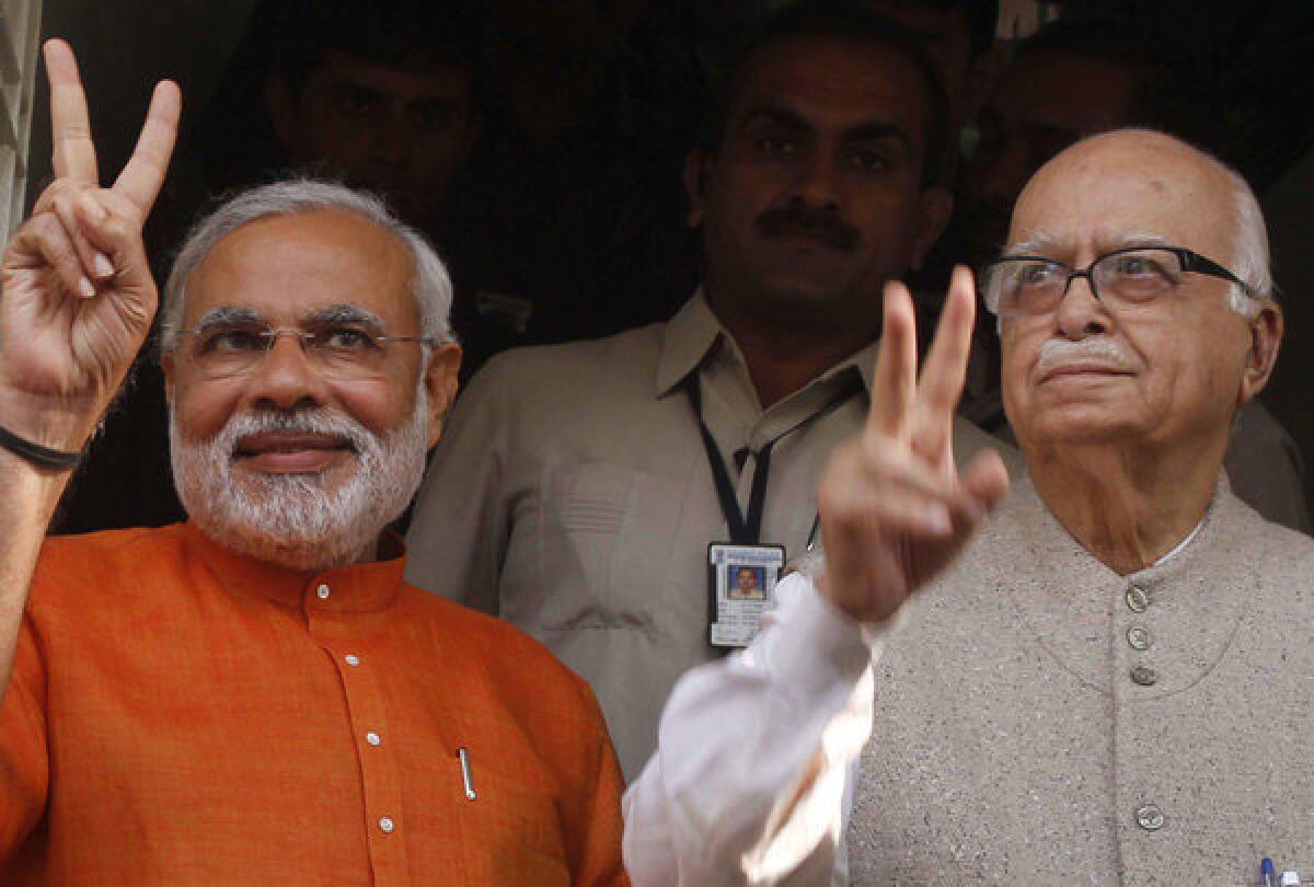 Gujarat Chief Minister Narendra Modi, left, flashes a victory sign as he sees off Bharatiya Janata Party (BJP) senior leader Lal Krishna Advani, right, after a meeting in December 2012 in Ahmadabad, India. Advani, one of the founding members of India's main opposition party, resigned from all party positions Monday, a day after the party appointed Modi to lead its campaign in national elections next year.