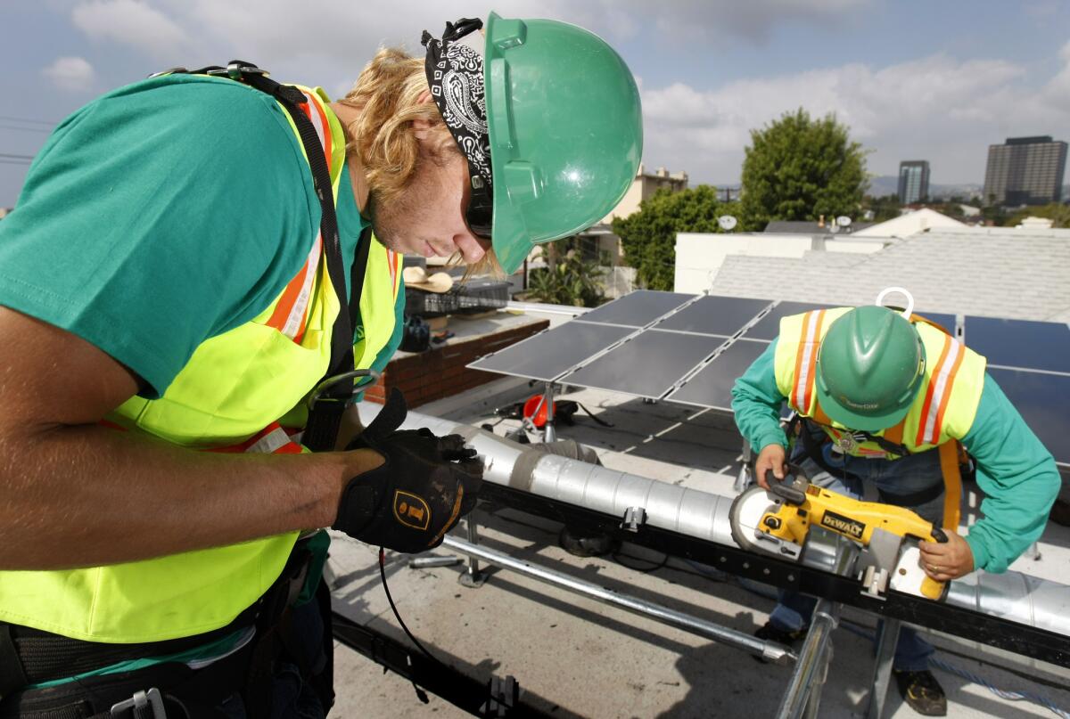 Solar panel installer Daniel Morabito, left, and Sal Sanchez install thin film technology solar panels for SolarCity in West Los Angeles in 2009.