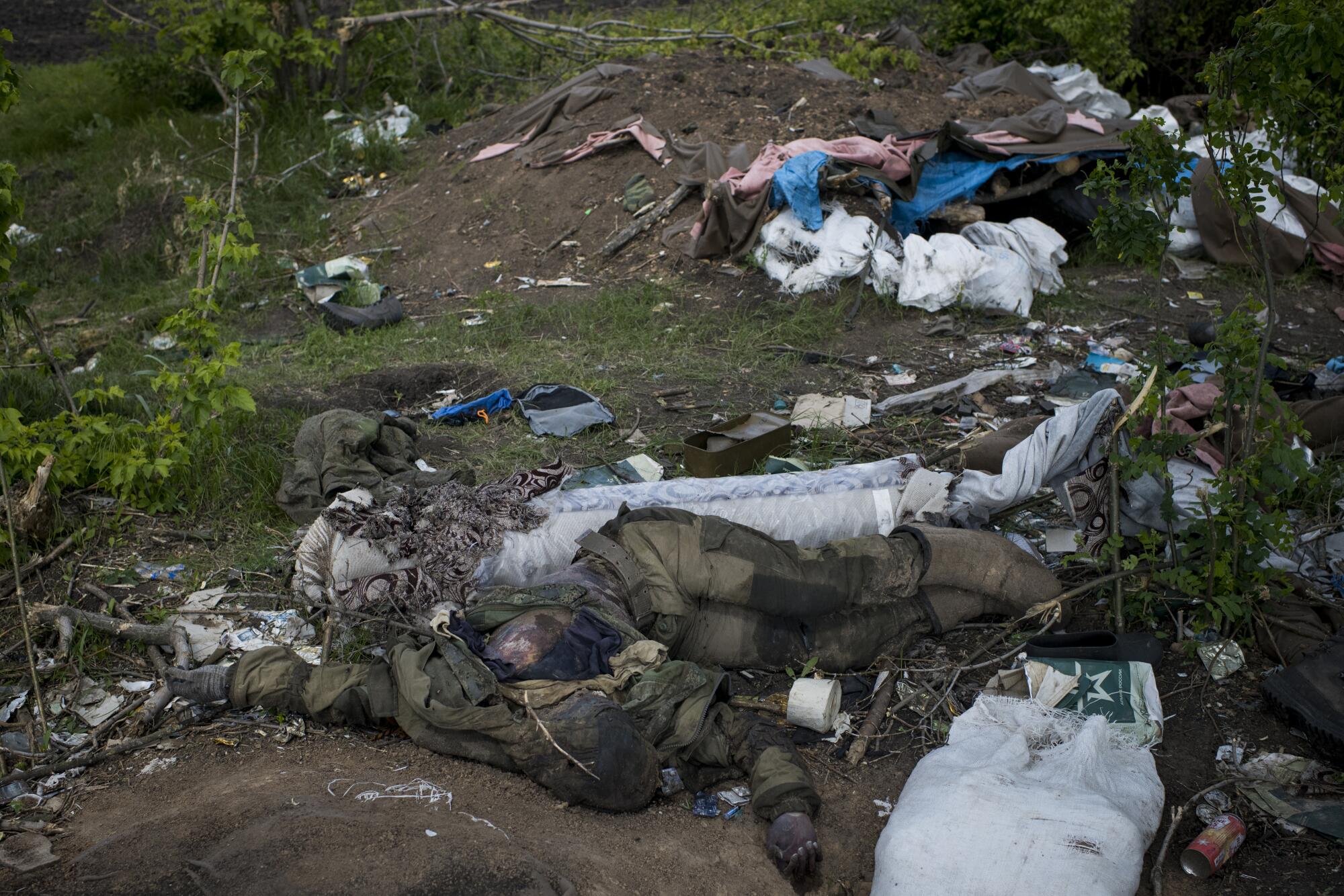 The body of a Russian soldier lies near debris.