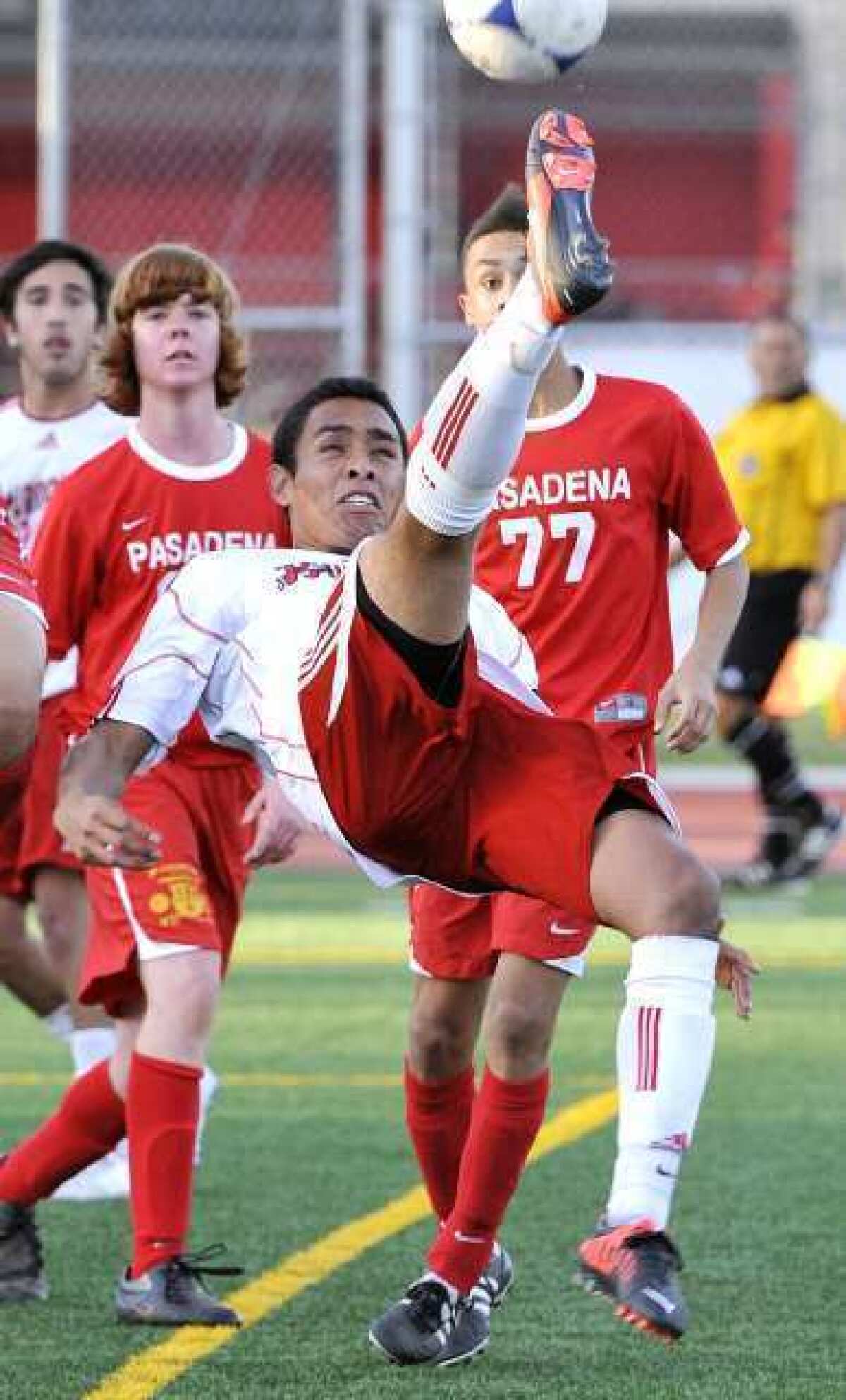 Burroughs' Manny Celio leans and jumps to attempt a bicycle kick shot towards goal against Pasadena in the second half in a Pacific League boys soccer match at Burroughs High School in Burbank on Monday, January 28, 2013. Pasadena won the match 3-1.