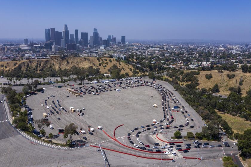 LOS ANGELES, CA - JULY 08: Hundreds line up for COVID-19 testing in the parking lot at Dodger Stadium in the drone image on Wednesday, July 8, 2020 in Los Angeles, CA. (Brian van der Brug / Los Angeles Times)