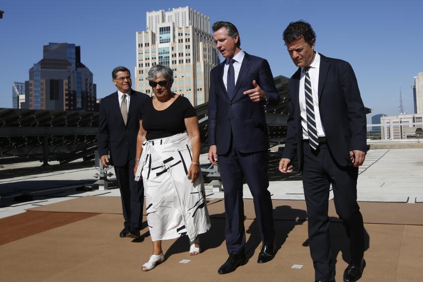 Calif Gov. Gavin Newsom, second from right, tours the solar panels atop the building housing the California Environmental Protection Agency accompanied by Attorney General Xavier Becerra, left, California Air Resources Board Chairwoman Mary Nichols, and California EPA Director Jared Blumenfeld, right in Sacramento, Calif., Tuesday, Aug. 13, 2019. California is part of coalition of 22 Democrat-led states that is suing the Trump administration over its decision to ease restrictions on coal-fired power plants. (AP Photo/Rich Pedroncelli)