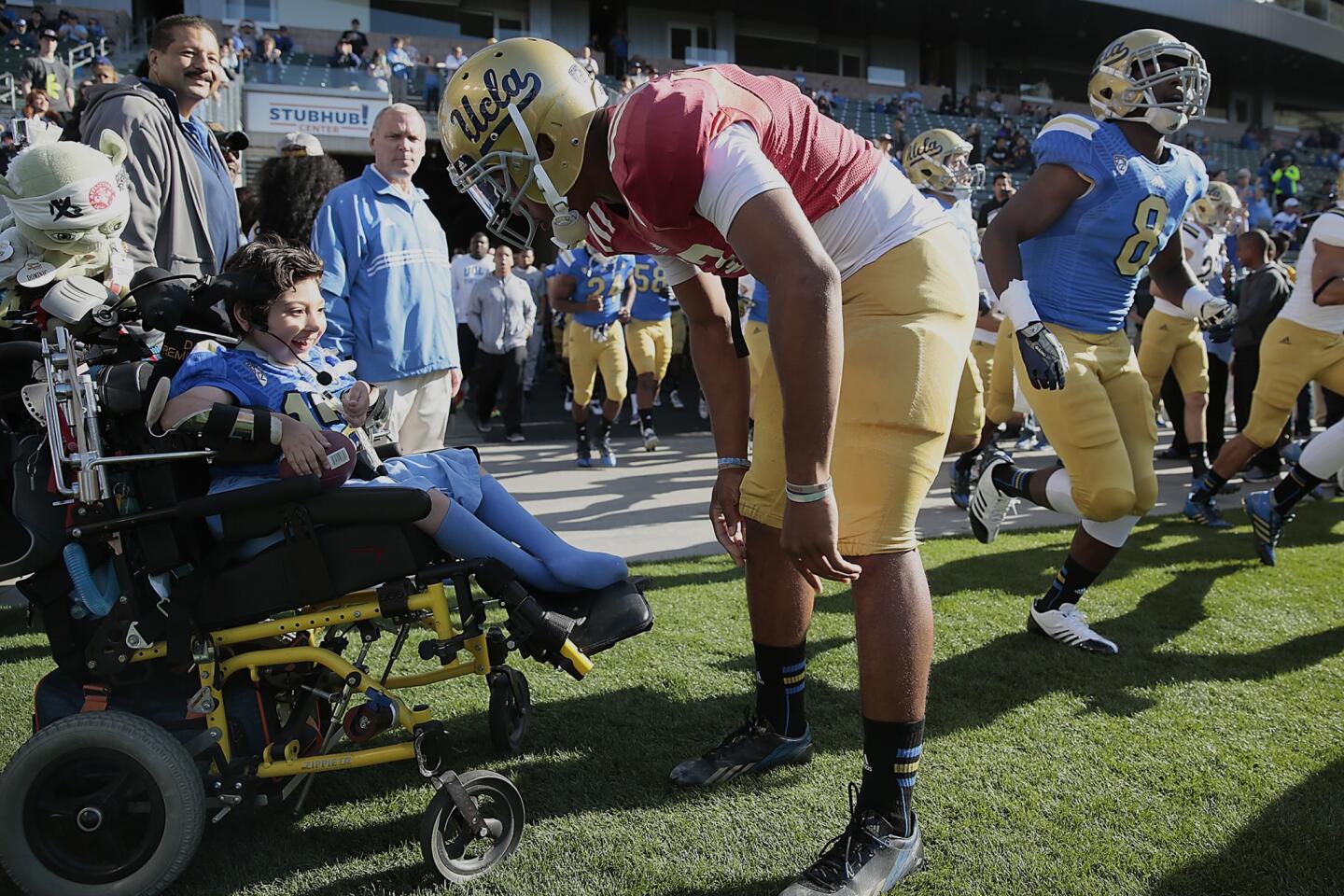 Bruins quarterback Brett Hundley greets 10-year-old Dominic Cumo before he takes the field for UCLA's spring game.