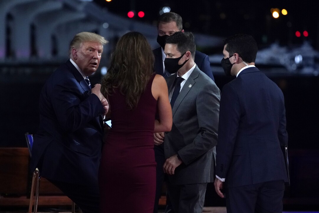 President Trump, without a mask, speaks to masked staffers