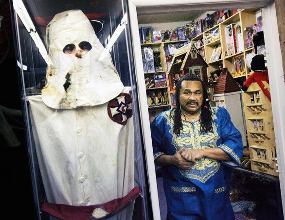 Oran Z. Belgrave, who owns the Pan African Black Facts & Wax Museum in Los Angeles, shows an authentic Ku Klux Klan outfit on display there. The museum, open by appointment only, houses thousands of items related to African American history that Belgrave has collected over the years. Now he's thinking about finding new homes for his collection.