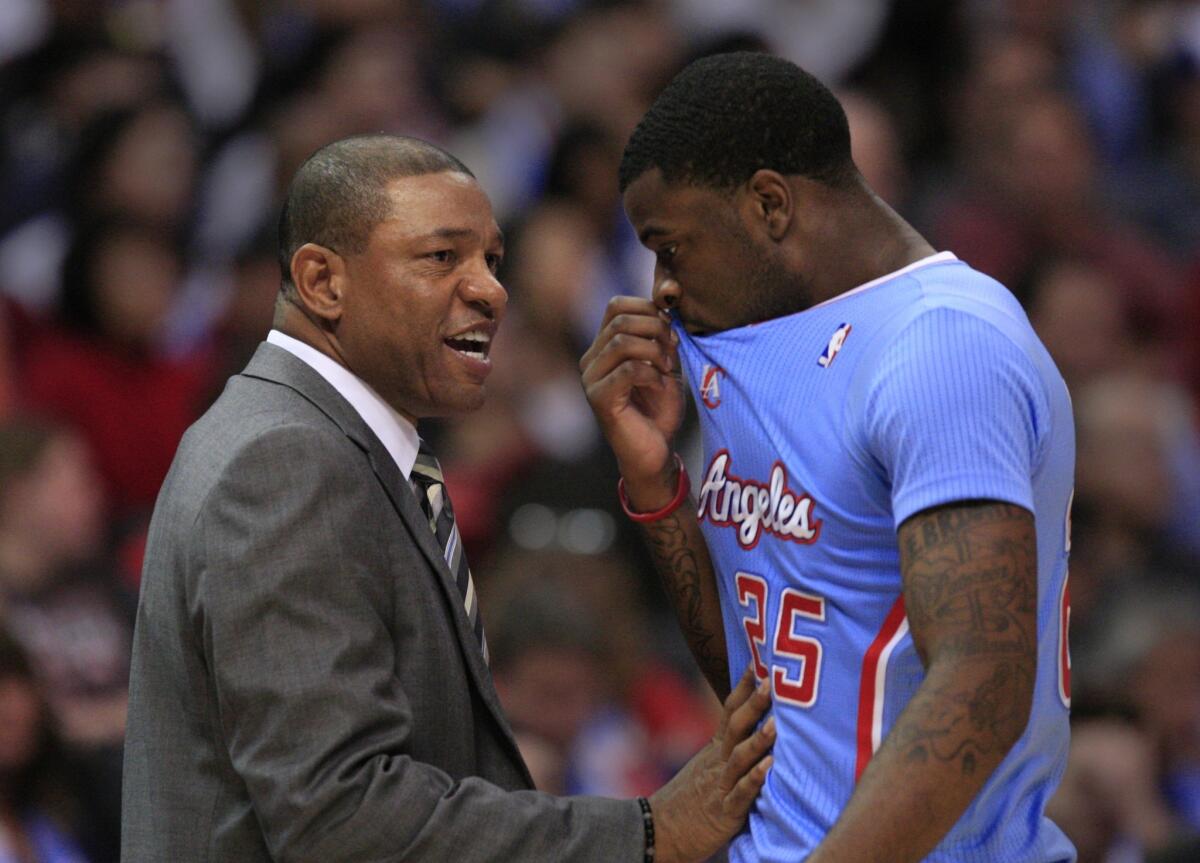 Clippers Coach Doc Rivers talks with forward Reggie Bullock during a game against the Chicago Bulls last November at Staples Center.