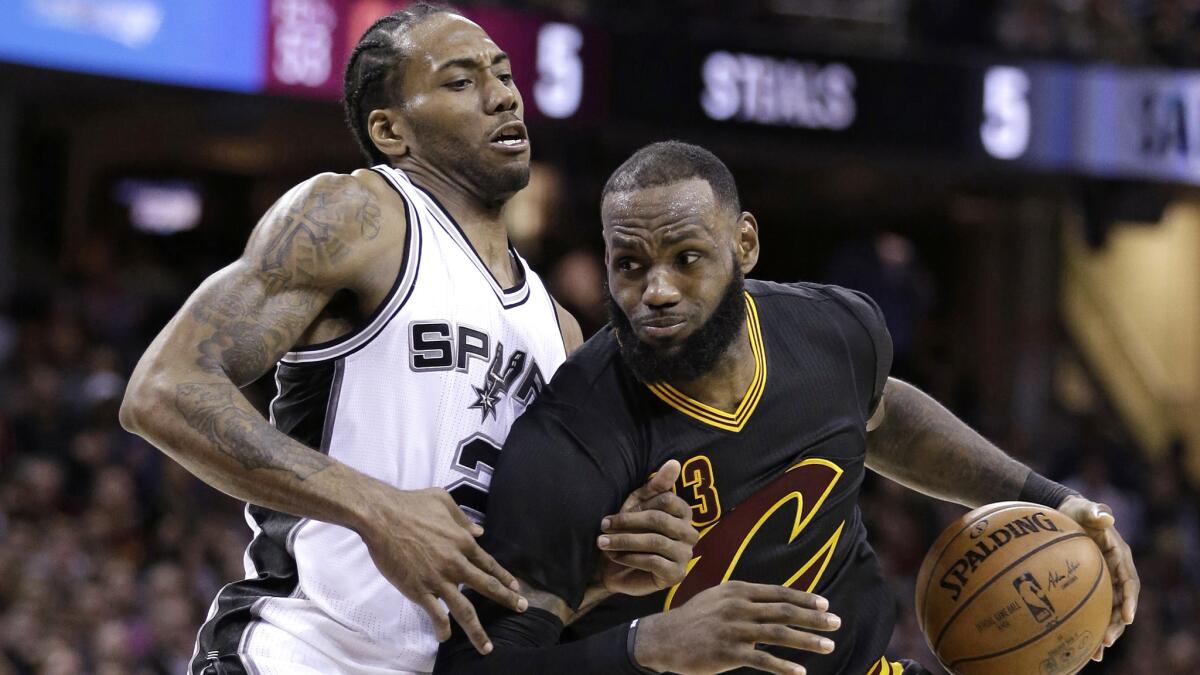 Cavaliers forward LeBron James tries to drive past Spurs forward Kawhi Leonard during a game in 2017.