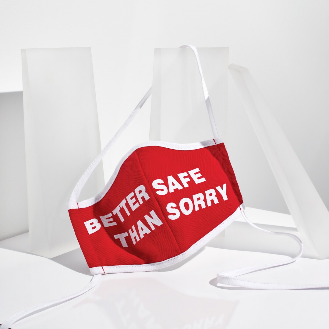 A red facial mask with the words "Better safe than sorry" printed in white