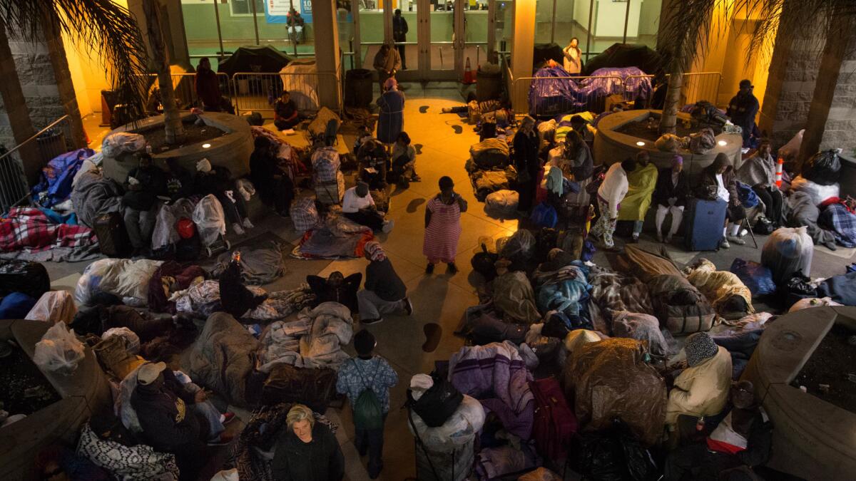 Homeless people, mostly women, spend the night in the courtyard of the Midnight Mission shelter for their safety on April 25.