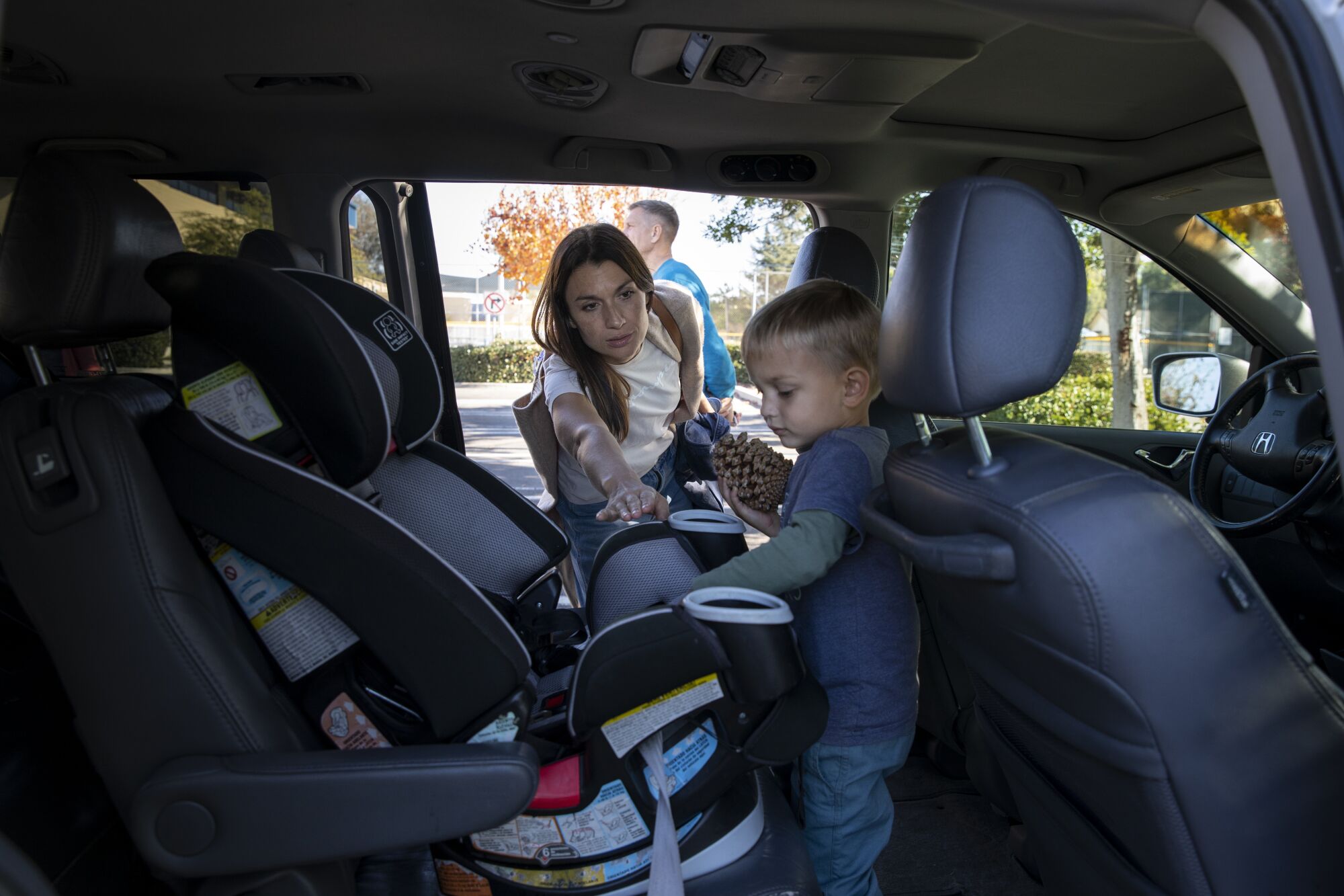 Anna Ermak puts Konstantin in a car seat as they get ready to leave Grape Day Park.