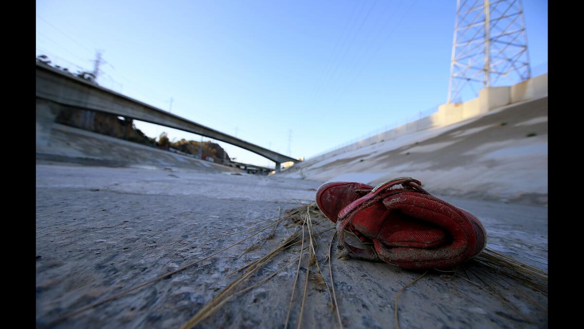 An old red sneaker rests in the bed of the Los Angles River.