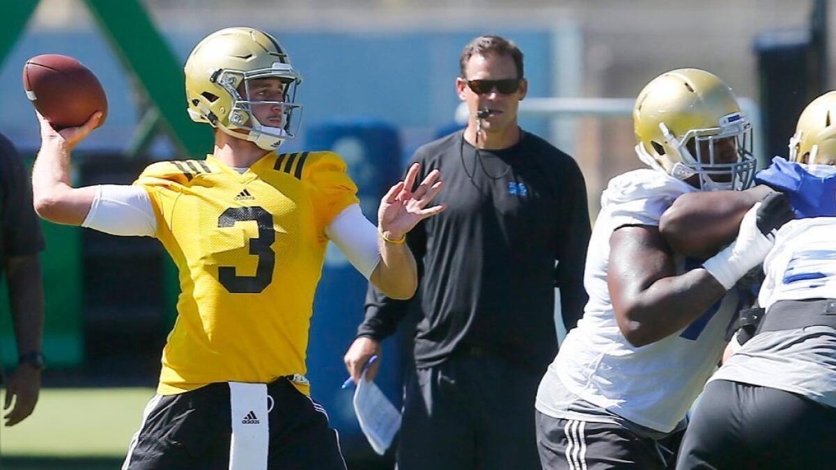 UCLA Coach Jim Mora watches as quarterback Josh Rosen throws a pass during a training camp practice on Aug. 15.