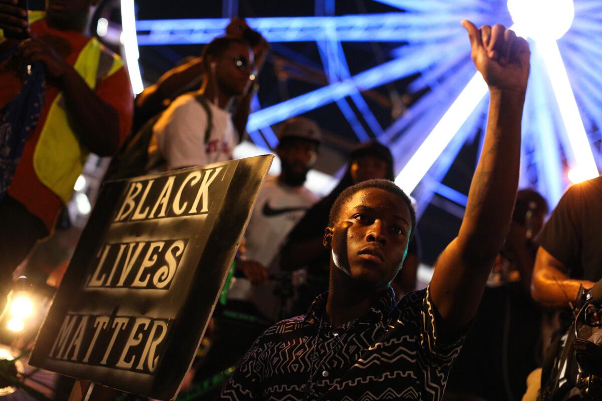 A demonstrator holds a sign during a protest in Atlanta in response to recent police shootings in North Carolina and Oklahoma.
