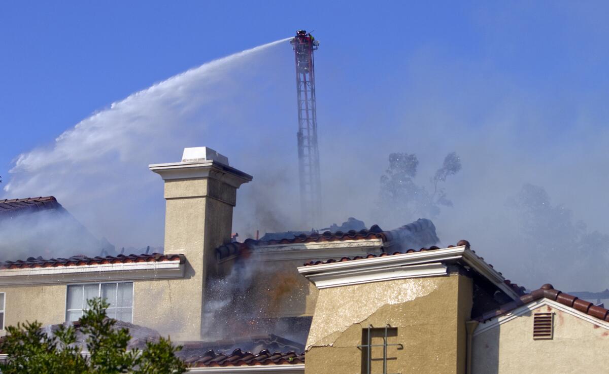 Firefighters spray water on an apartment complex in Carlsbad.