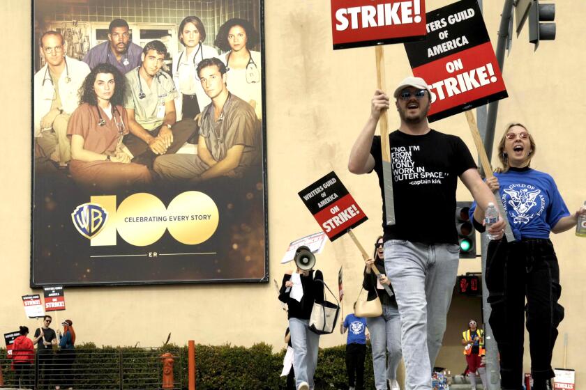 BURBANK, CA - MAY 4, 2023 - WGA members walk the picket line in front of Warner Brothers Studios on the third day of the WGA strike in Burbank on May 3, 2023. (Genaro Molina / Los Angeles Times)