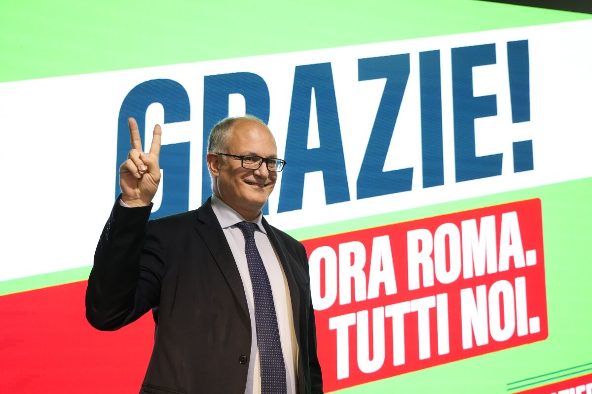 Center-left mayoral candidate Roberto Gualtieri flashes a v-sign at his party's headquarters in Rome, Monday, Oct. 18, 2021. Romans are waiting to learn who will be their next mayor, following runoff elections that ended Monday in the Italian capital. The top vote-getters in the first round of balloting two weeks earlier, Enrico Michetti, a novice politician backed by a far-right leader, and Roberto Gualtieri, a Democrat and former finance minister, competed in the runoff Sunday and Monday. Italian writing in background read: 'Thank you! Now Rome. All of us. (AP Photo/Gregorio Borgia)