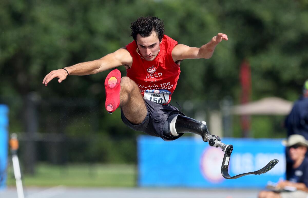 Ezra Frech sails through the air as he competes in men’s long jump at the U.S. Paralympic team trials in July. 