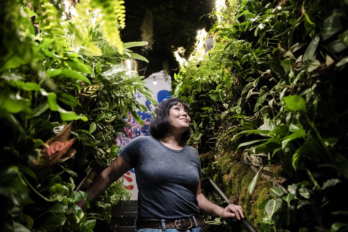 Yuko Watanabe inside a tunnel made of plants.