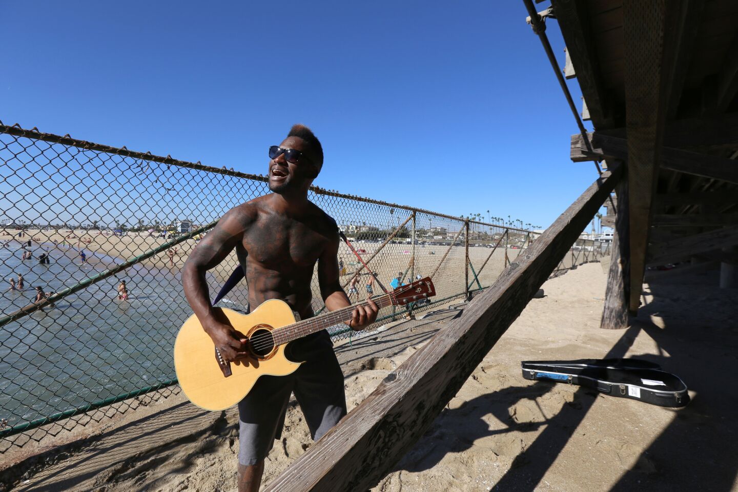 Johnny Griffin of Long Beach takes in the cool ocean breeze while playing guitar next to the Seal Beach Pier.