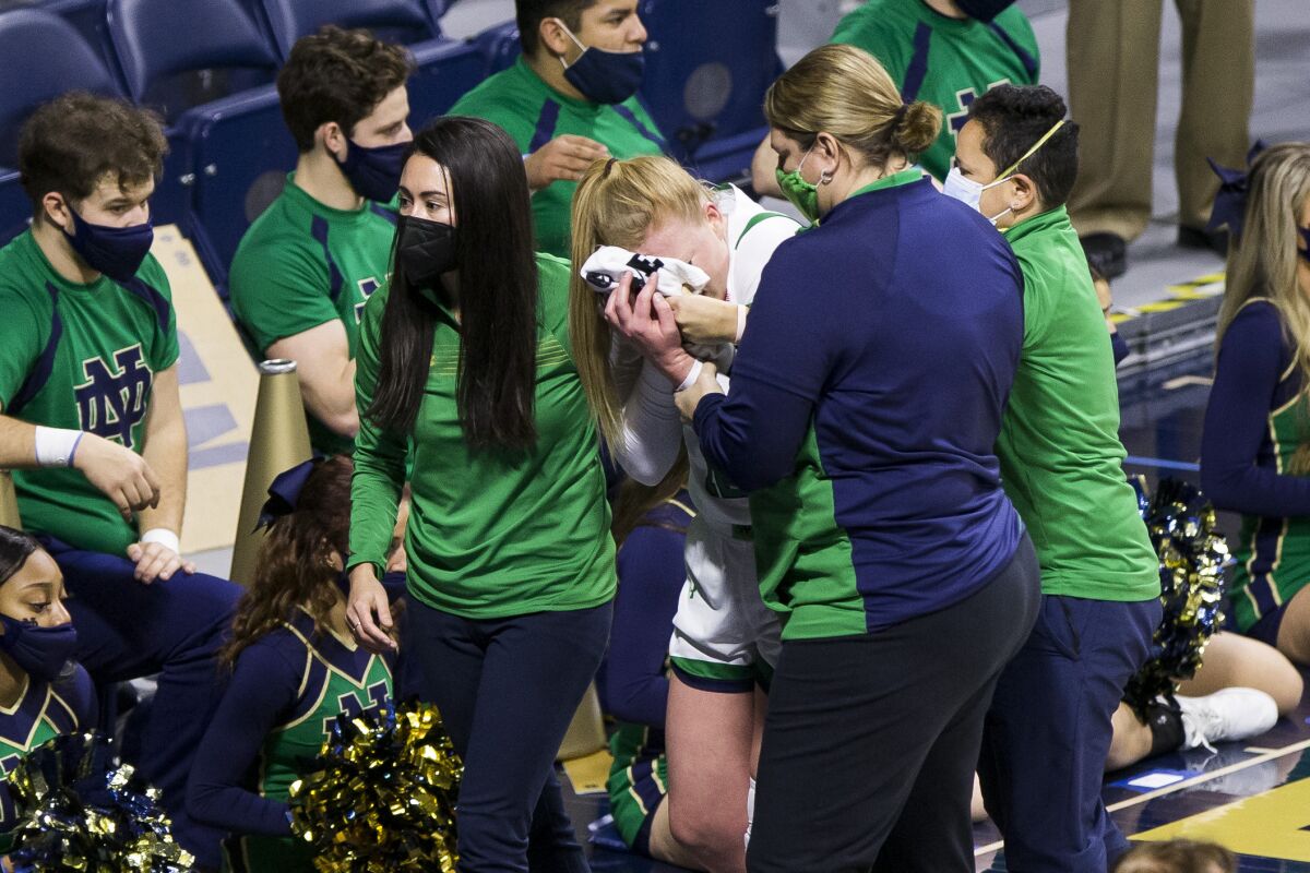 Notre Dame's Abby Prohaska leaves with an injury during the first half of the team's NCAA college basketball game against North Carolina State on Tuesday, Feb. 1, 2022, in South Bend, Ind. (AP Photo/Robert Franklin)
