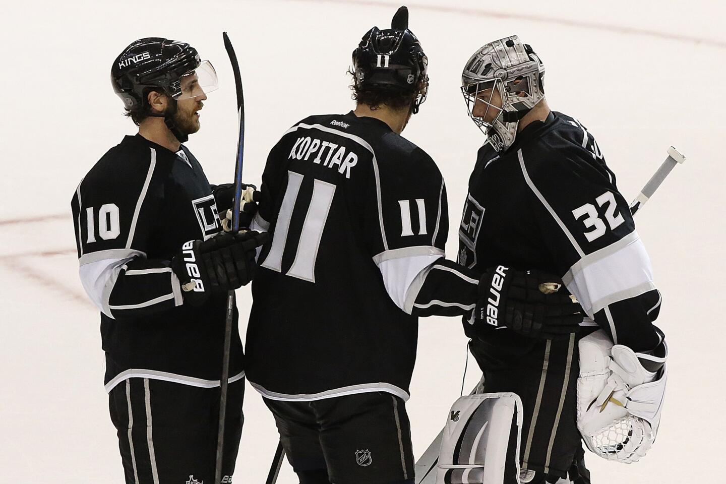 Kings goalie Jonathan Quick celebrates a 2-1 victory over the Ducks with teammates Anze Kopitar and Mike Richards on Wednesday night at Staples Center.