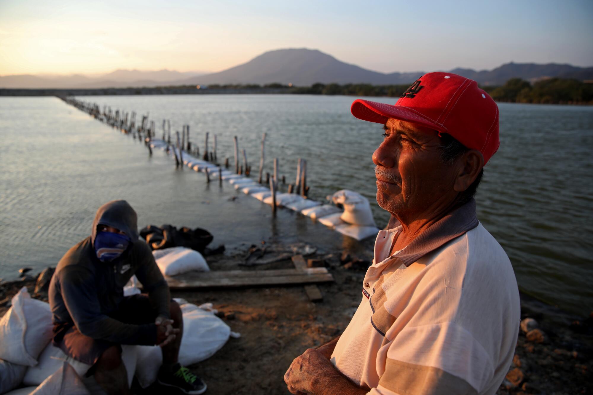 A man and his son pause while working on the water.