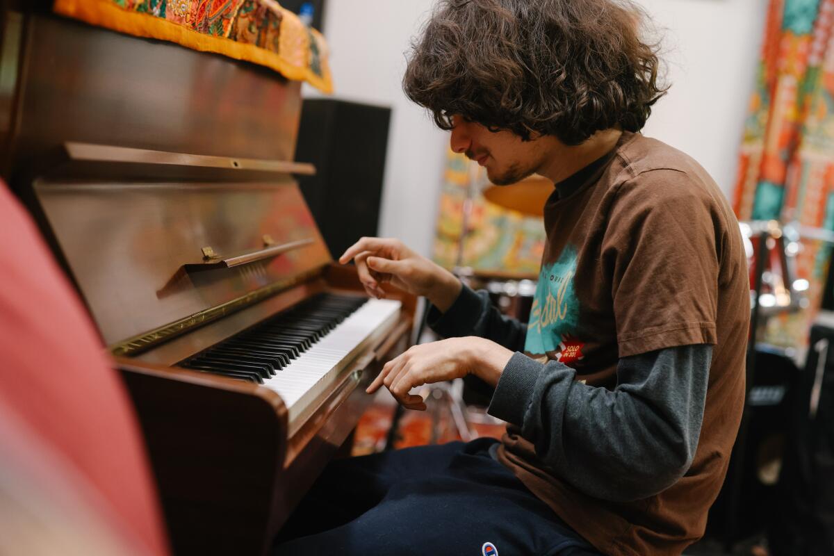 A teenager plays the piano.