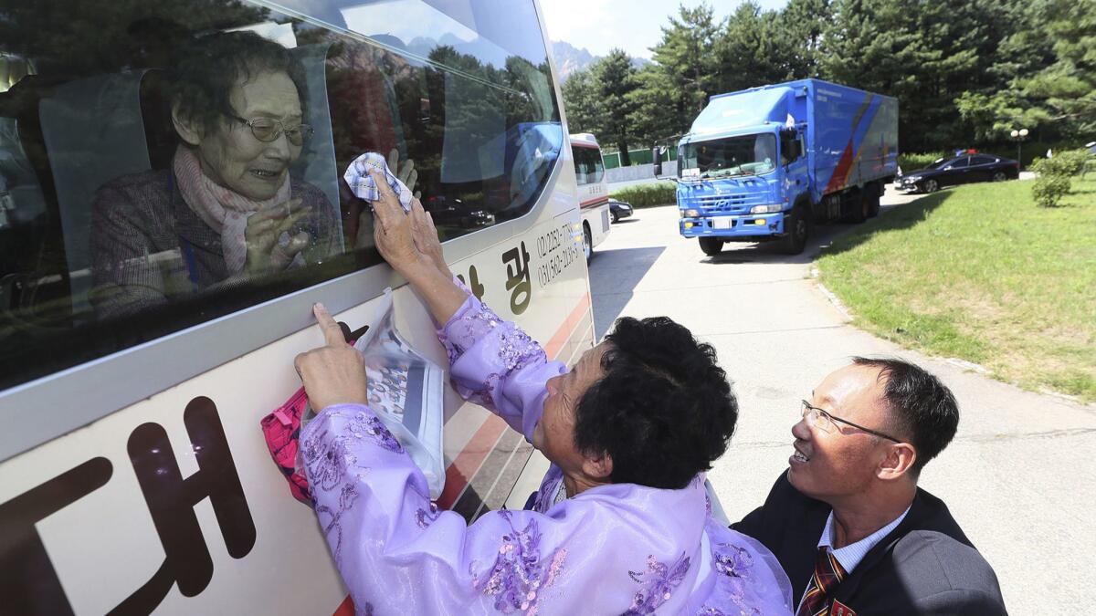 North Korean Kim Kyong Sil, 72, touches a bus window as she says farewell to her mother, South Korean Han Shin-ja, 99, on Wednesday, following reunions held in the North between some relatives separated by the 1950-53 Korean War.