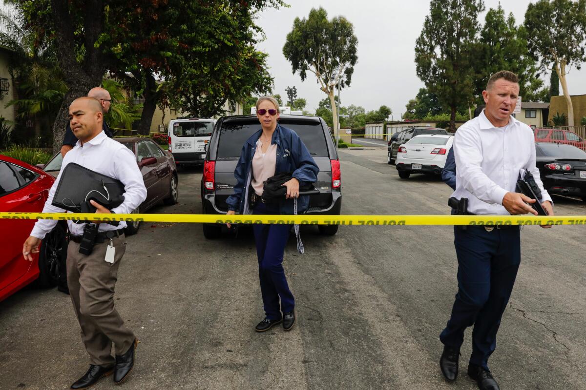 Police investigators work at the Casa De Portola apartment complex in Garden Grove where the first two victims in a stabbing rampage were attacked Wednesday.