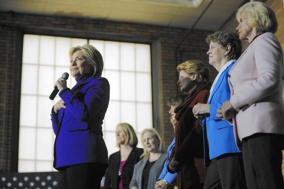 Hillary Clinton is joined by Lilly Ledbetter, right, and several Democratic lawmakers in Manchester, N.H.