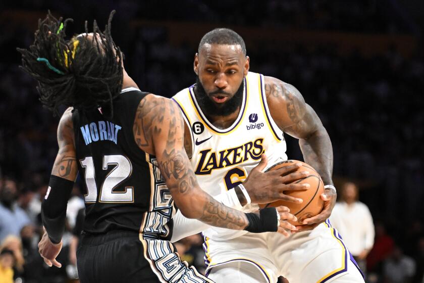 Los Angeles, California April 22, 2023-Lakers LeBron James runs through Grizzlies Ja Morant to score a basket in the third quarter in Game 3 of the first round of the NBA playoffs at Crypto.com arena Saturday. (Wally Skalij/Los Angeles Times)