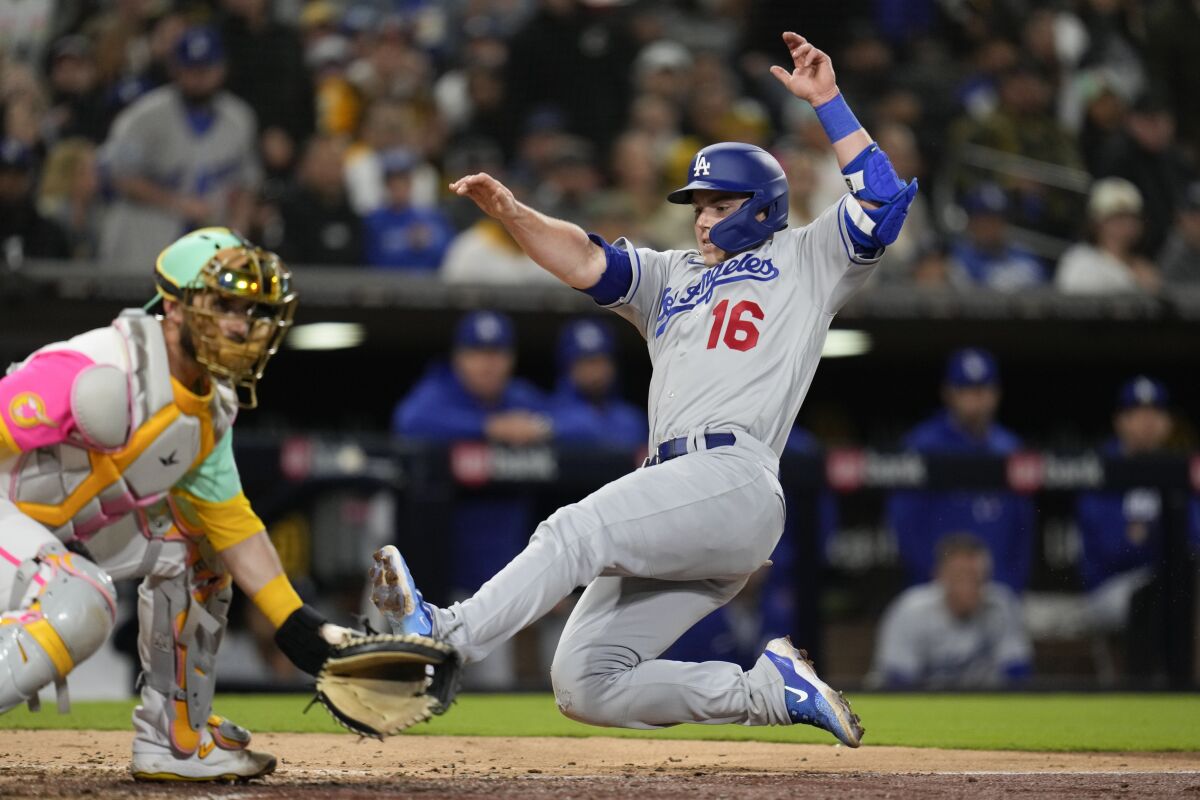 Dodgers baserunner Will Smith slides into home past Padres catcher Austin Nola in the seventh inning Friday.