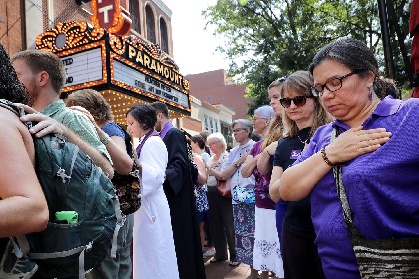 Clergy observe a moment of silence during the memorial service for Heather Heyer outside the Paramount Theater August 16, 2017 in Charlottesville, Virginia. The memorial service was held four days after Heyer was killed when a participant in a white nationalist, neo-Nazi rally allegedly drove his car into the crowd of people demonstrating against the 'alt-right' gathering.