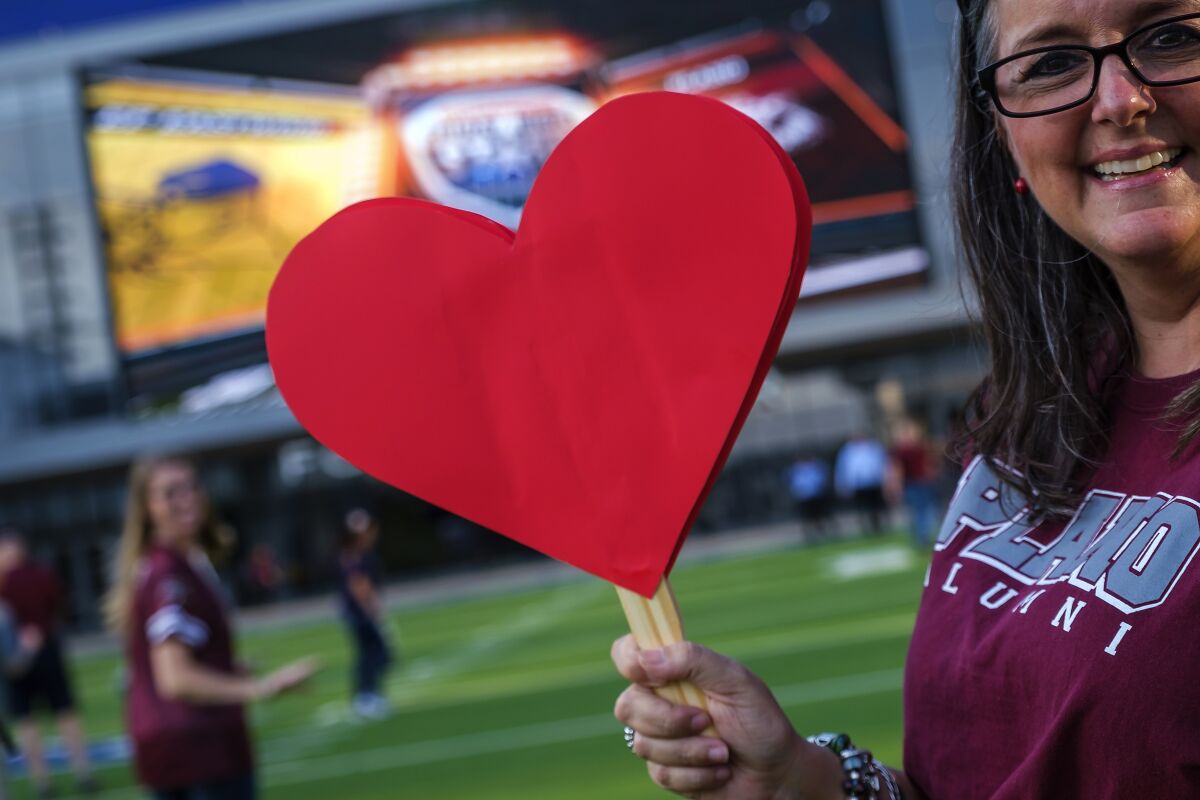 Plano High alumnus Suzanne Wilson arrives with cut-out hearts before a high school football game against El Paso Eastwood on Sept. 5.