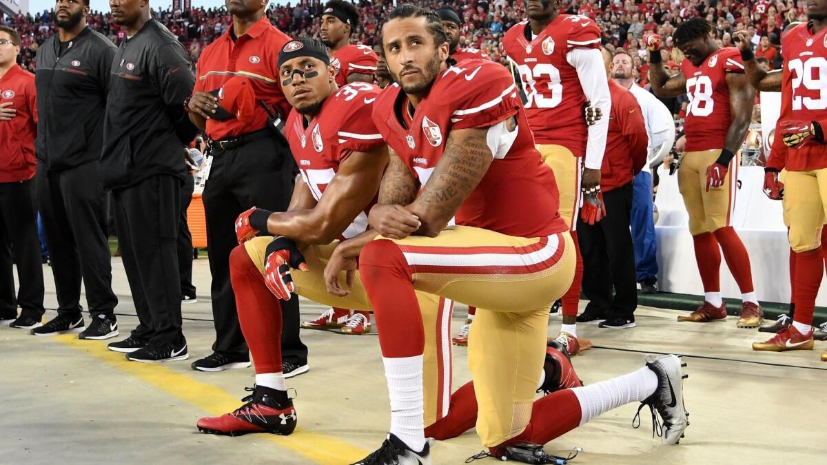 Colin Kaepernick, right, and Eric Reid of the San Francisco 49ers kneel in protest during the national anthem in 2016.