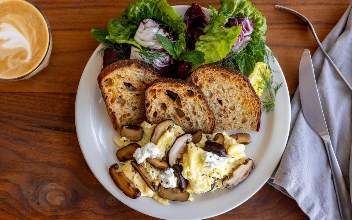 A shiitake scramble on a plate with slices of toast and salad