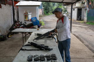 Reynano López 46, an avocado farmer, starts his morning shift with the self-defense militia.