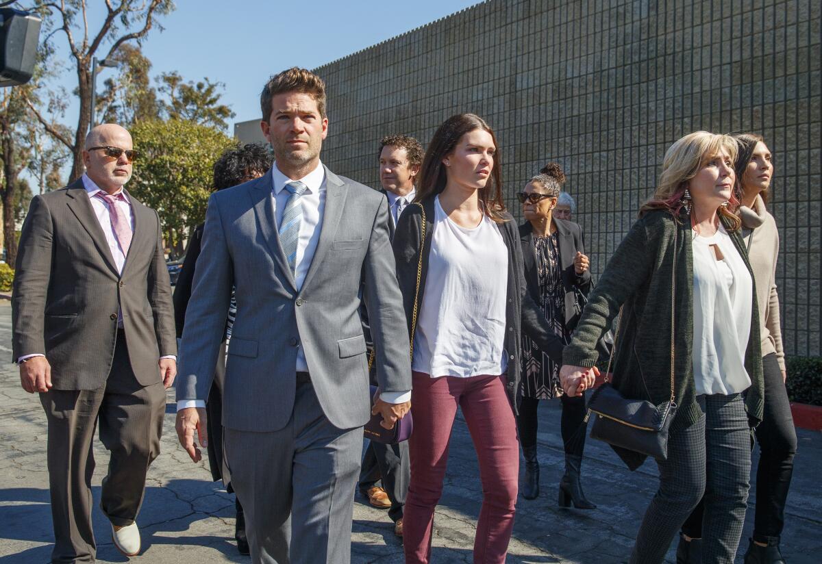 Defense attorney Philip Cohen, left, Grant Robicheaux, center, and his girlfriend Cerissa Riley walk outdoors with others